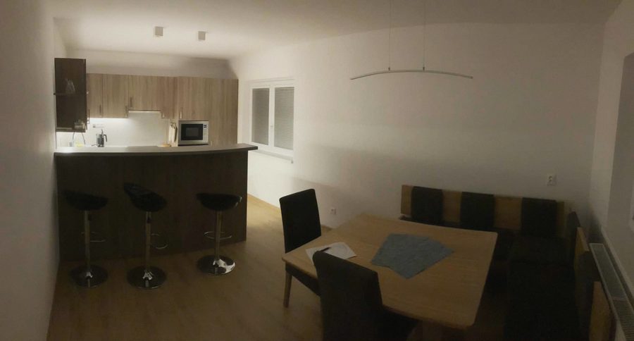 Kuchyně s barem, barovými židlemi a jídelním koutem